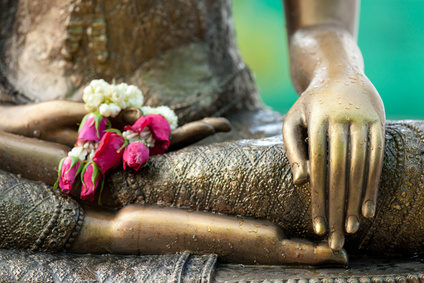 flowers on a Buddhist statue, representing mindfulness guidance