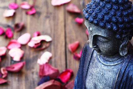 buddhist statue with flower petals, , representing mindfulness guidance