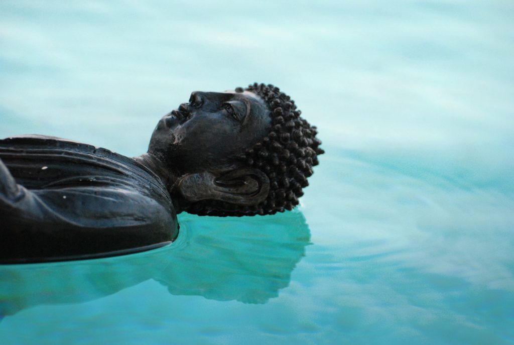 Buddhist statue floating on water, representing a body scan meditation