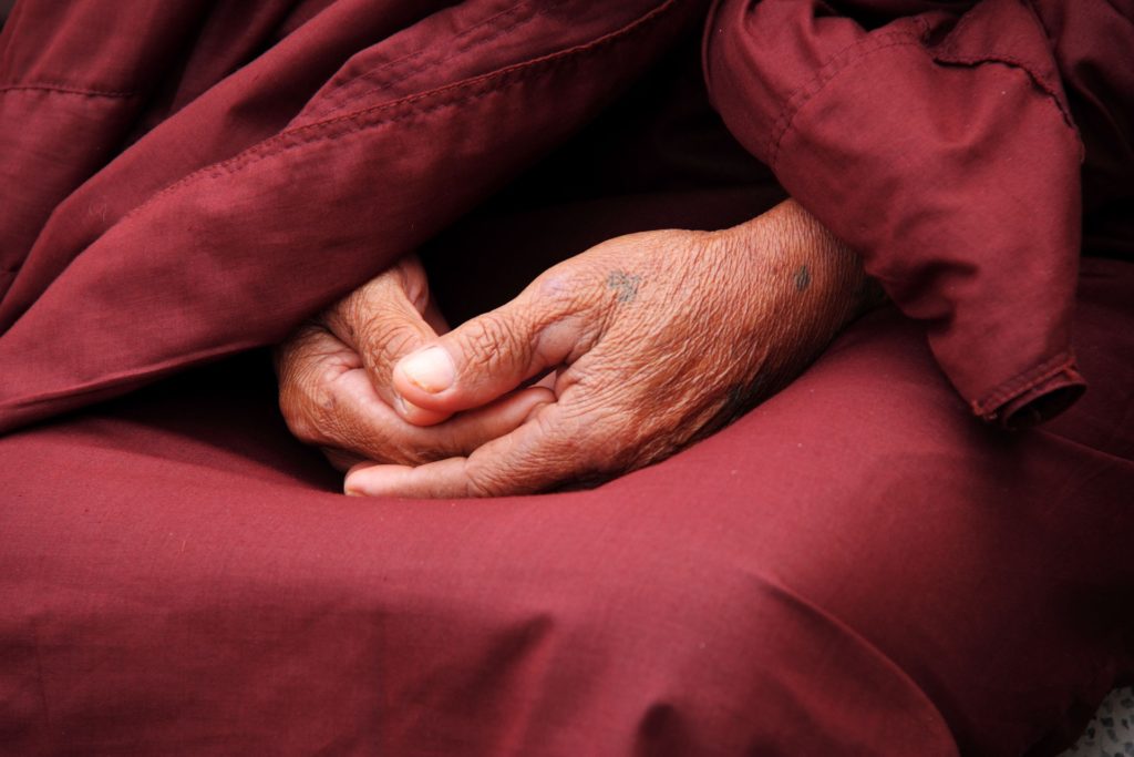 monk hands symbolizing letting go around death