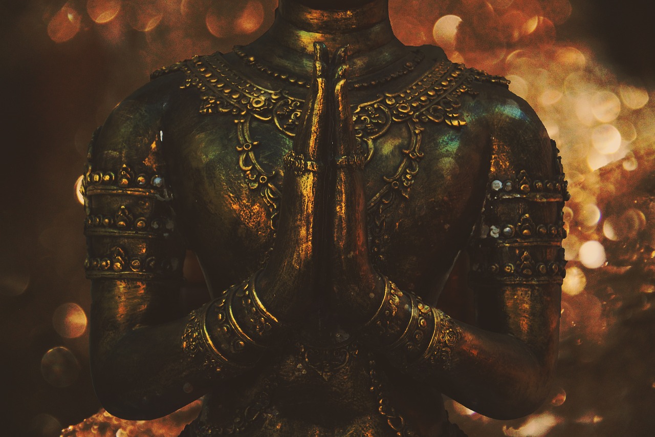 buddhist statue with hands in prayer